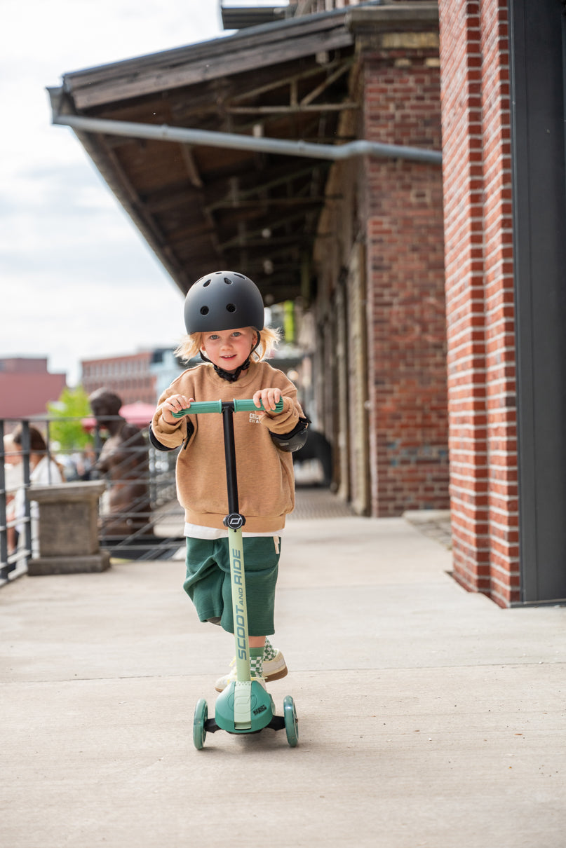 Child riding the Scoot and Ride Highway Kick 3S LED Scooter outdoors