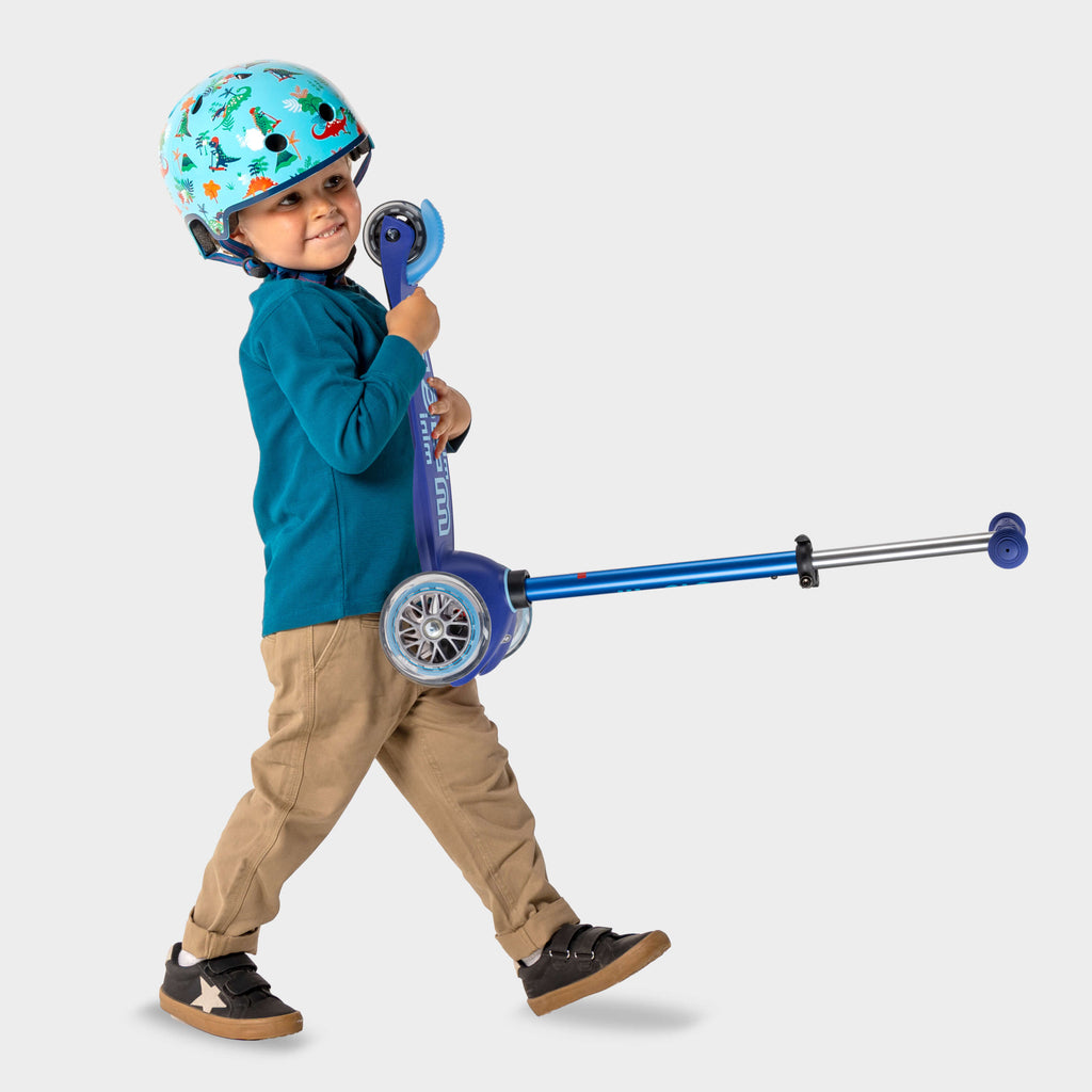 A child enjoying the Mini Micro Deluxe LED scooter outdoors