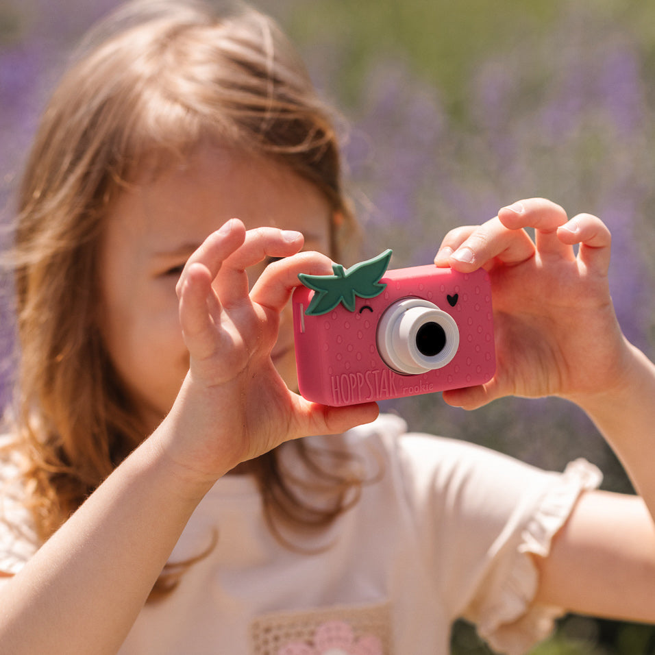 A child happily using the Hoppstar Rookie camera outdoors