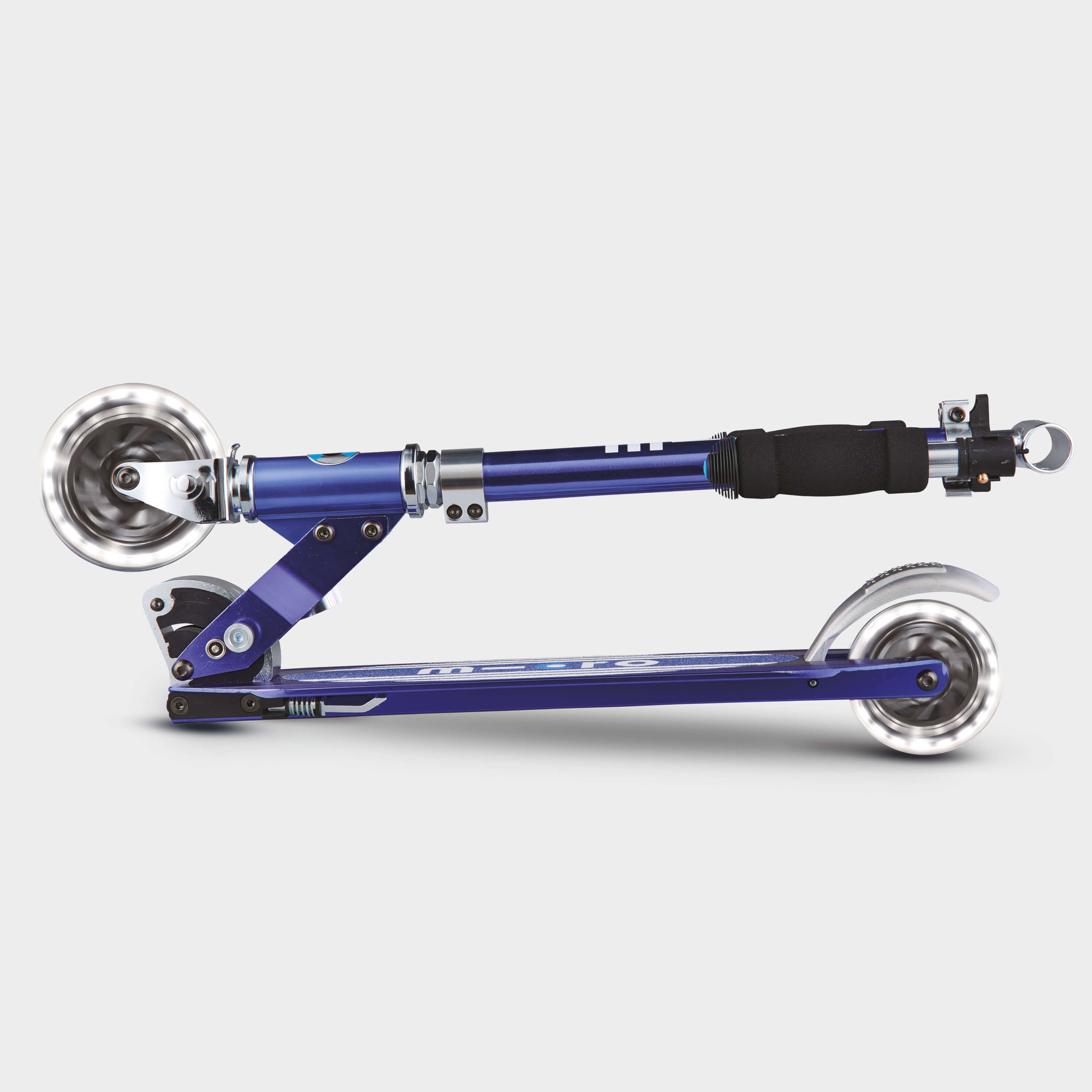 Child riding a Micro Sprite LED scooter outdoors