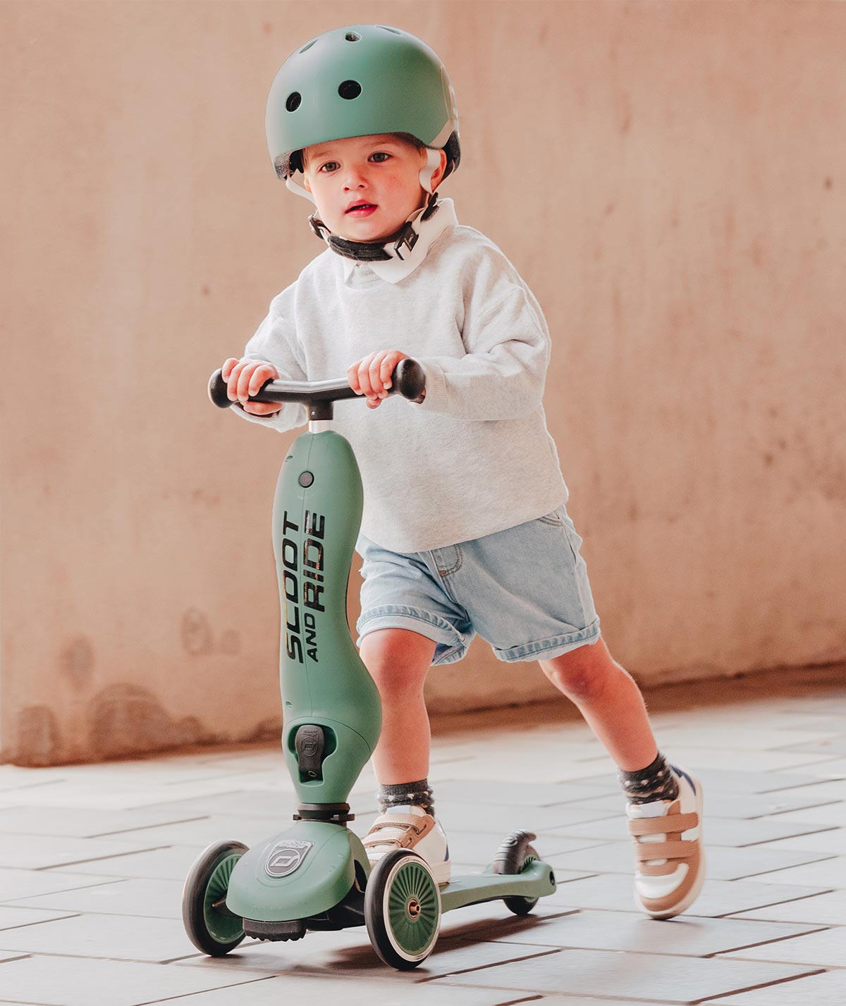 Child riding the Scoot and Ride Highway Kick 1 Forest scooter outdoors